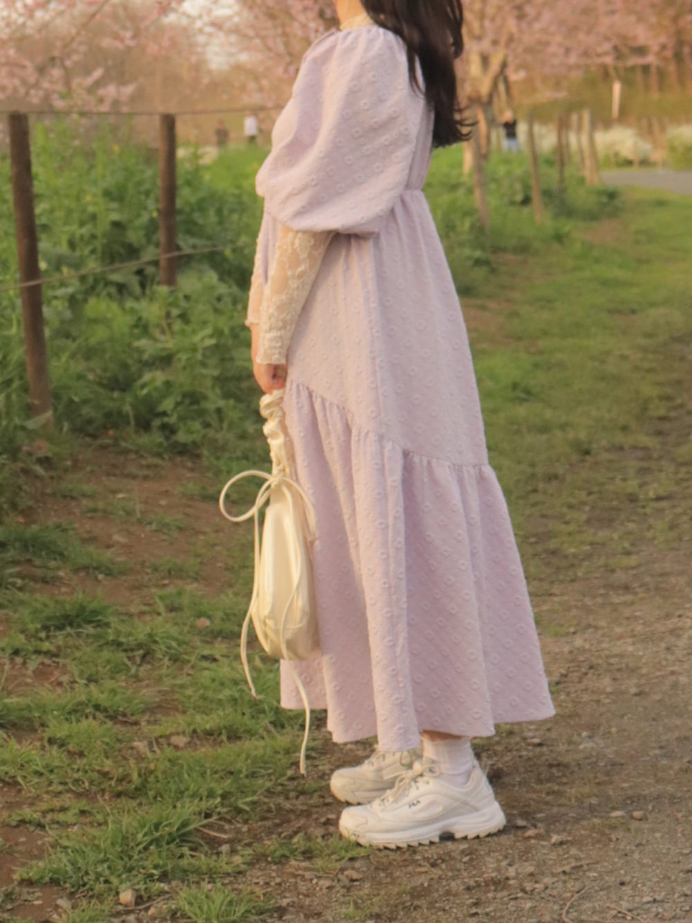 パープル系のワンピース、ホワイト系のバッグを着用したレディースの夏コーディネートの2枚目の写真