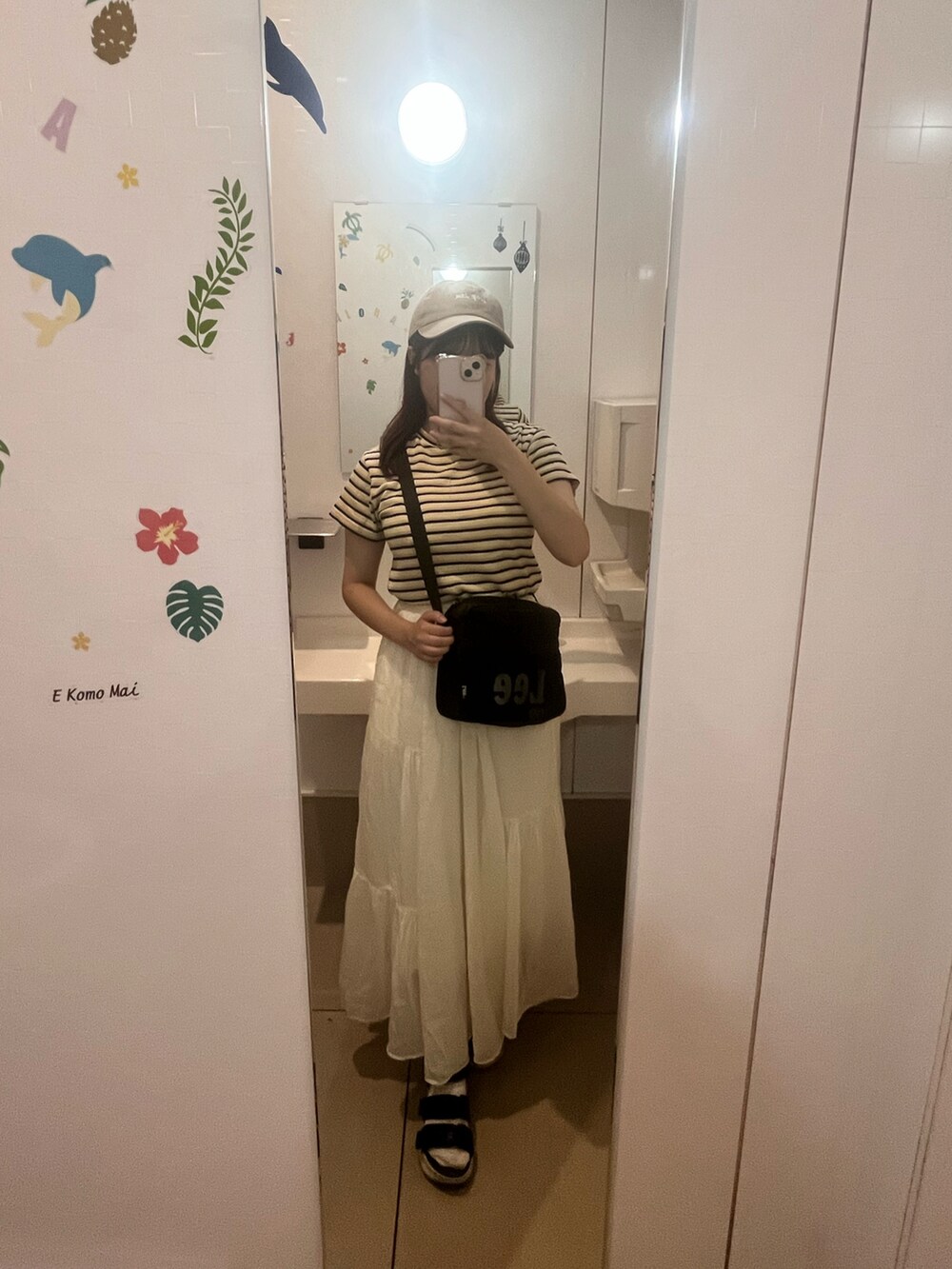 イエロー系のTシャツ/カットソー、ホワイト系のスカート、ブルー系のサンダルを着用したレディースの秋コーディネートの2枚目の写真