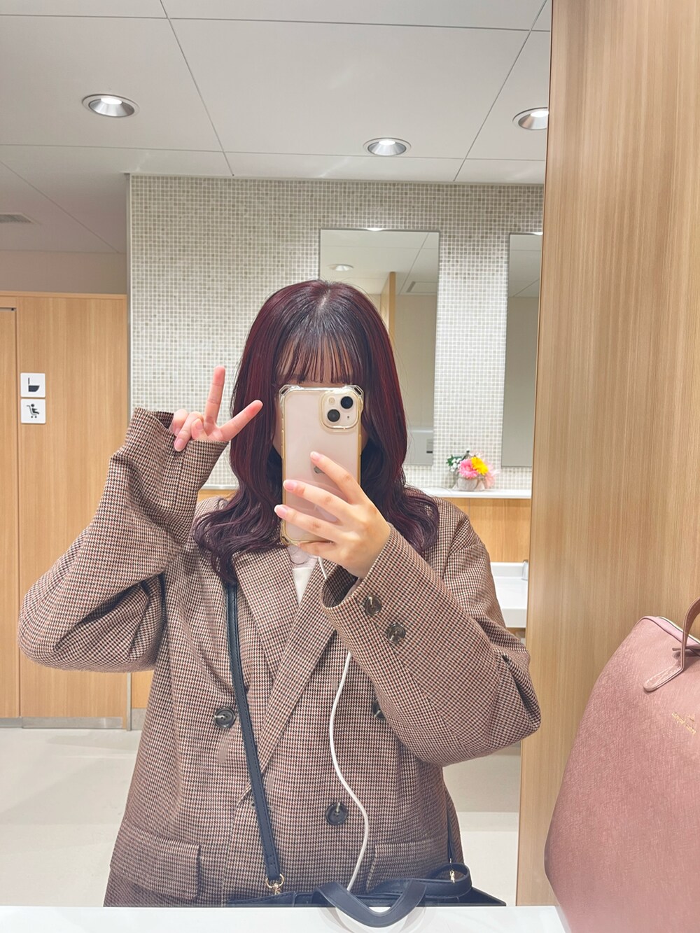 ブラック系のハンドバッグ、ベージュ系のワンピース、ブラウン系のテーラードジャケットを着用したレディースの冬コーディネートの2枚目の写真