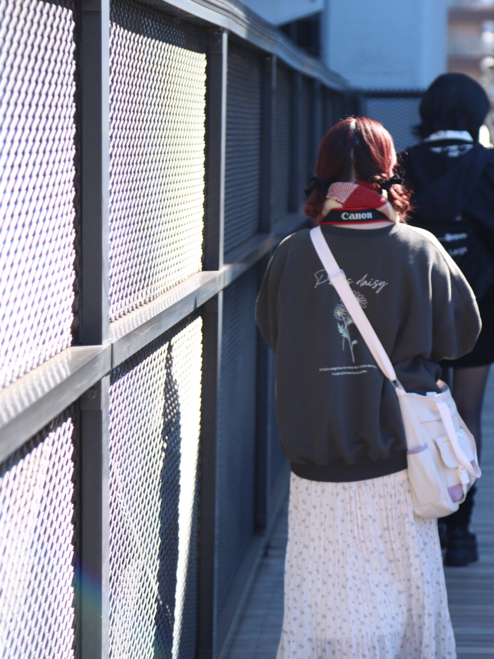 ブラック系のスウェット、ベージュ系のスカート、ホワイト系のスニーカーを着用したレディースの冬コーディネートの2枚目の写真