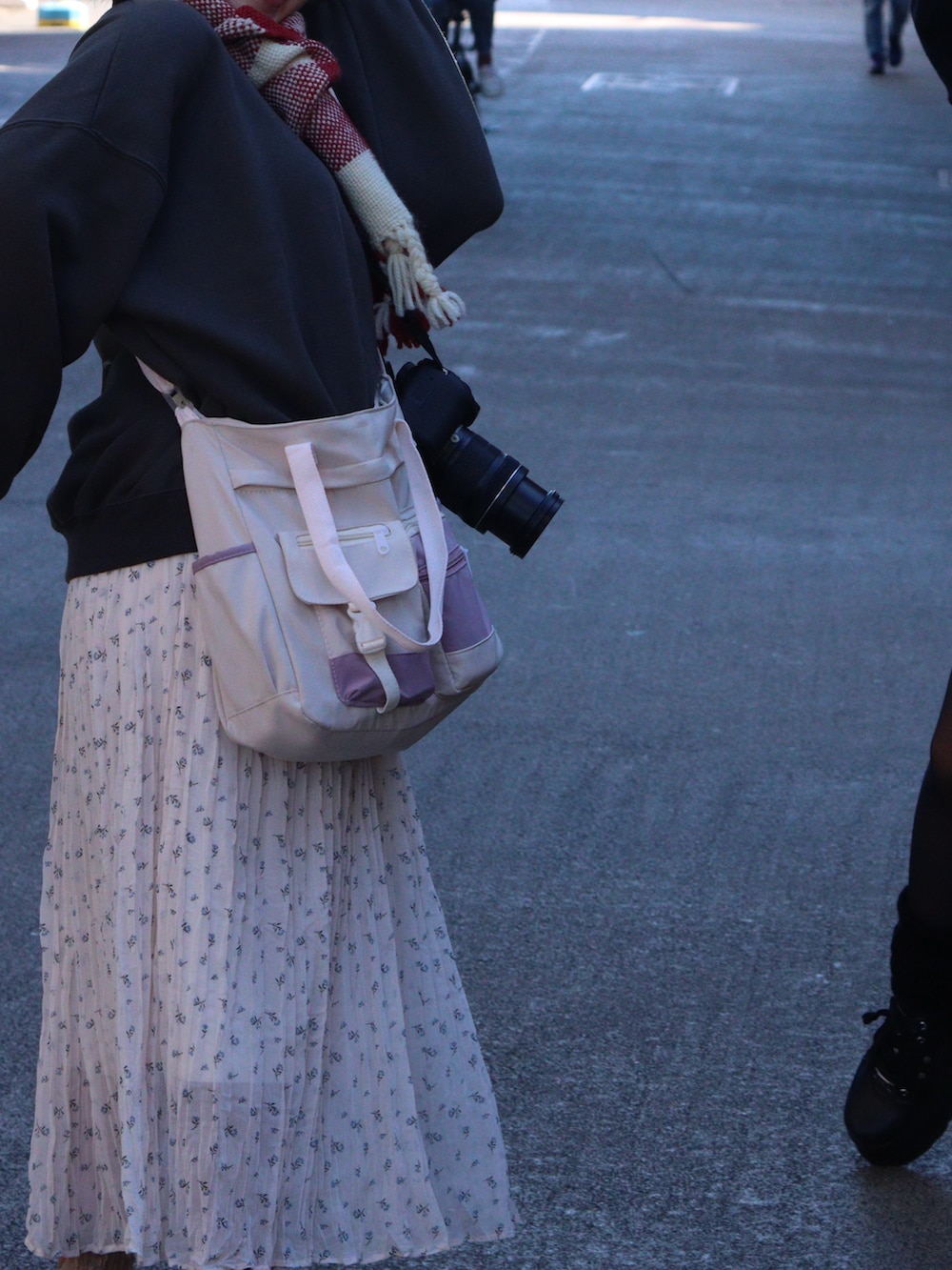 ブラック系のスウェット、ベージュ系のスカート、ホワイト系のスニーカーを着用したレディースの冬コーディネートの3枚目の写真