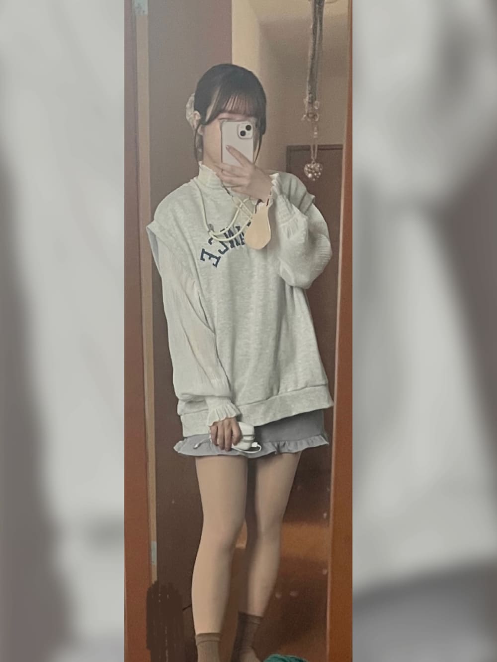 グレー系のスウェット、グレー系のスカート、ホワイト系のスニーカーを着用したレディースの夏コーディネートの2枚目の写真