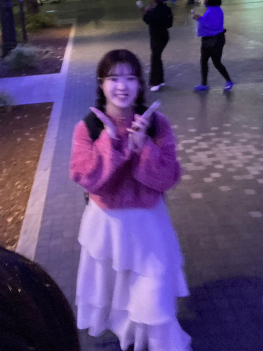 ピンク系のカーディガン/ボレロ、ホワイト系のスカート、ブラック系のバックパック/リュックを着用したレディースの冬コーディネートの2枚目の写真