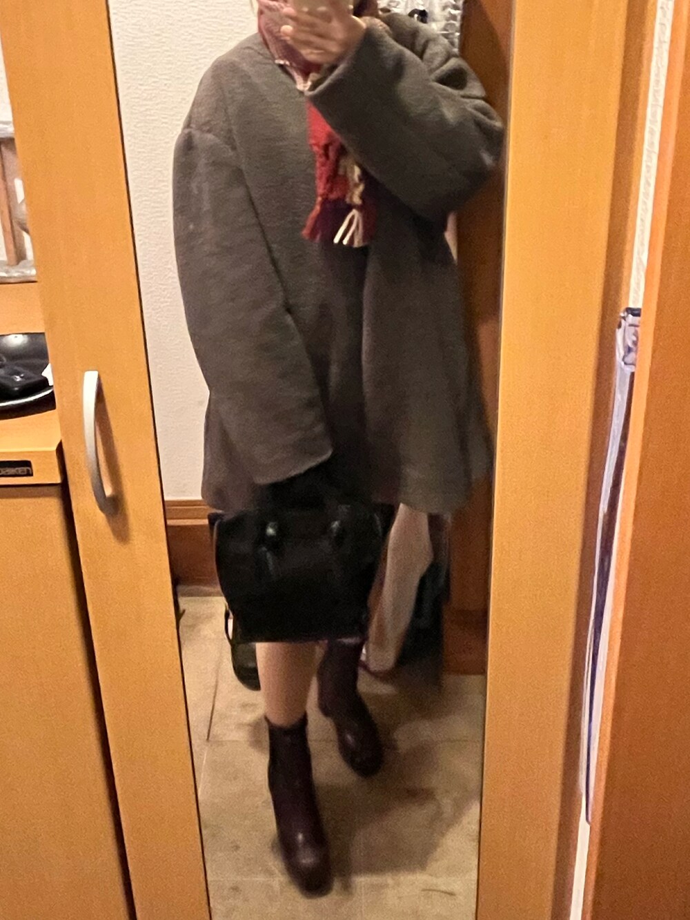 ブラック系のハンドバッグ、ブラウン系のブーツ、ブラウン系のジャケット/アウターを着用したレディースの冬コーディネートの2枚目の写真