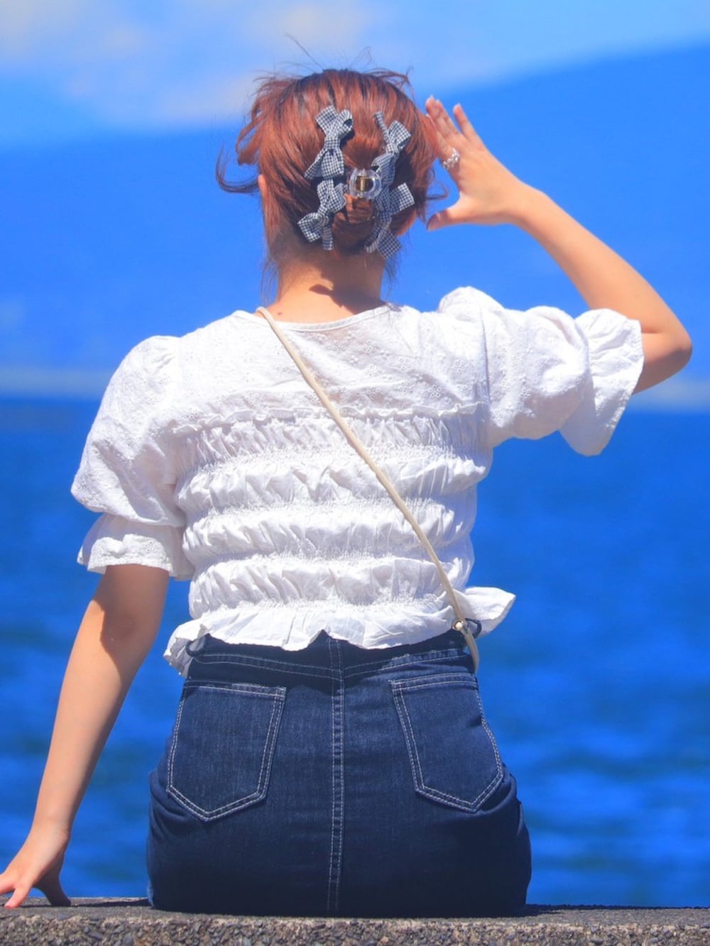 ホワイト系のシャツ/ブラウス、ブルー系のデニムスカート、ブラック系のバレッタ/ヘアクリップを着用したレディースの秋コーディネートの2枚目の写真