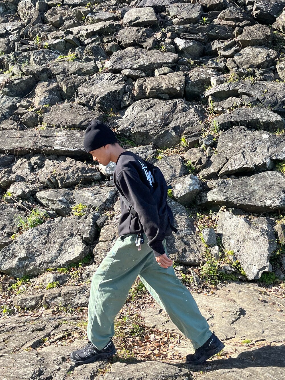 ブラック系のショルダーバッグ、ブラック系のスウェット、ブラック系のスニーカーを着用したメンズの春コーディネートの2枚目の写真