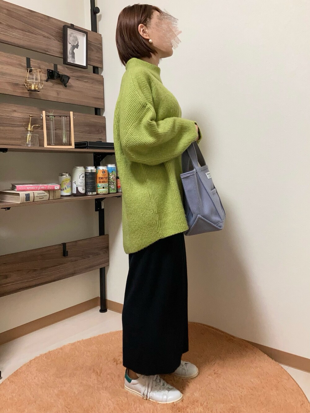 グリーン系のニット/セーター、ブラック系のスカート、パープル系のトートバッグを着用したレディースの秋コーディネートの2枚目の写真