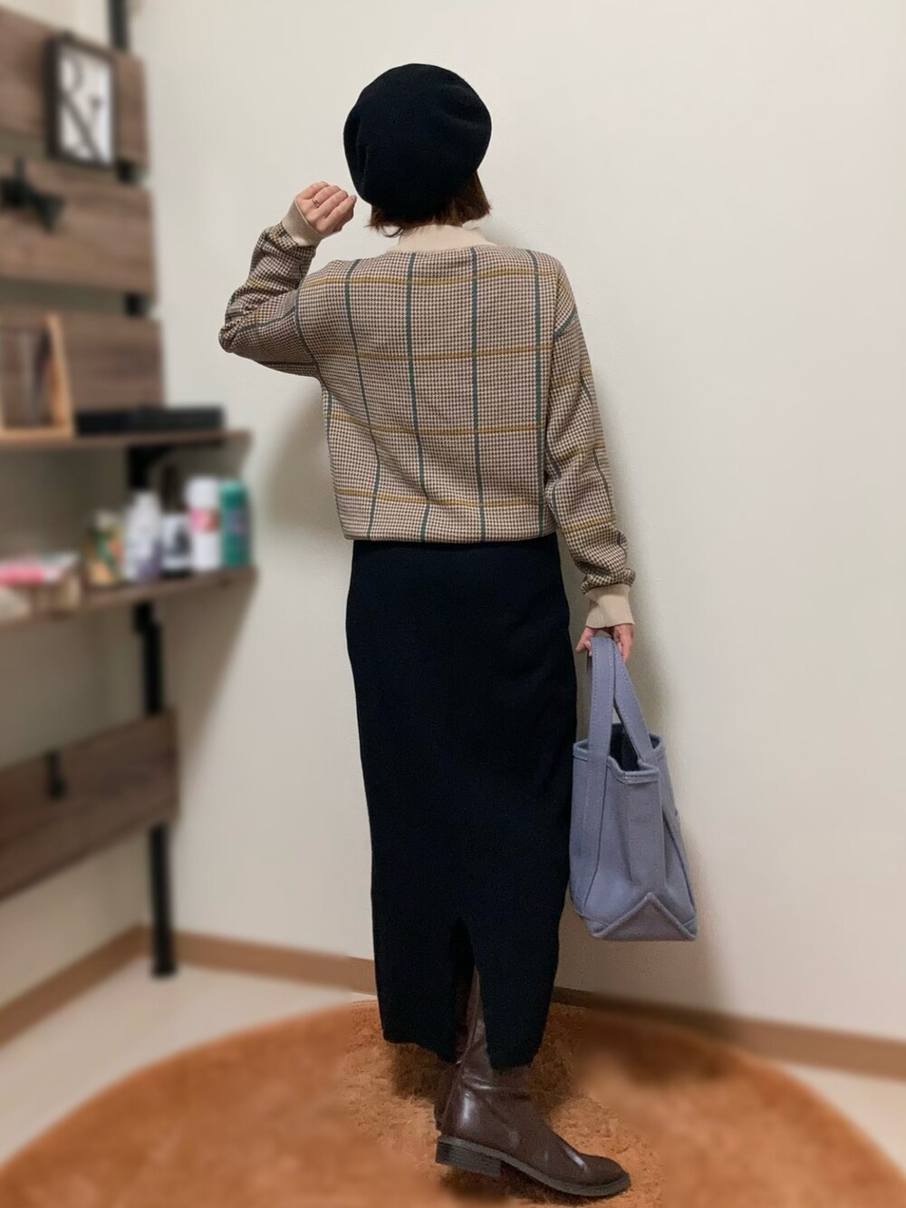 ベージュ系のニット/セーター、ブラック系のスカート、パープル系のトートバッグを着用したレディースの冬コーディネートの2枚目の写真