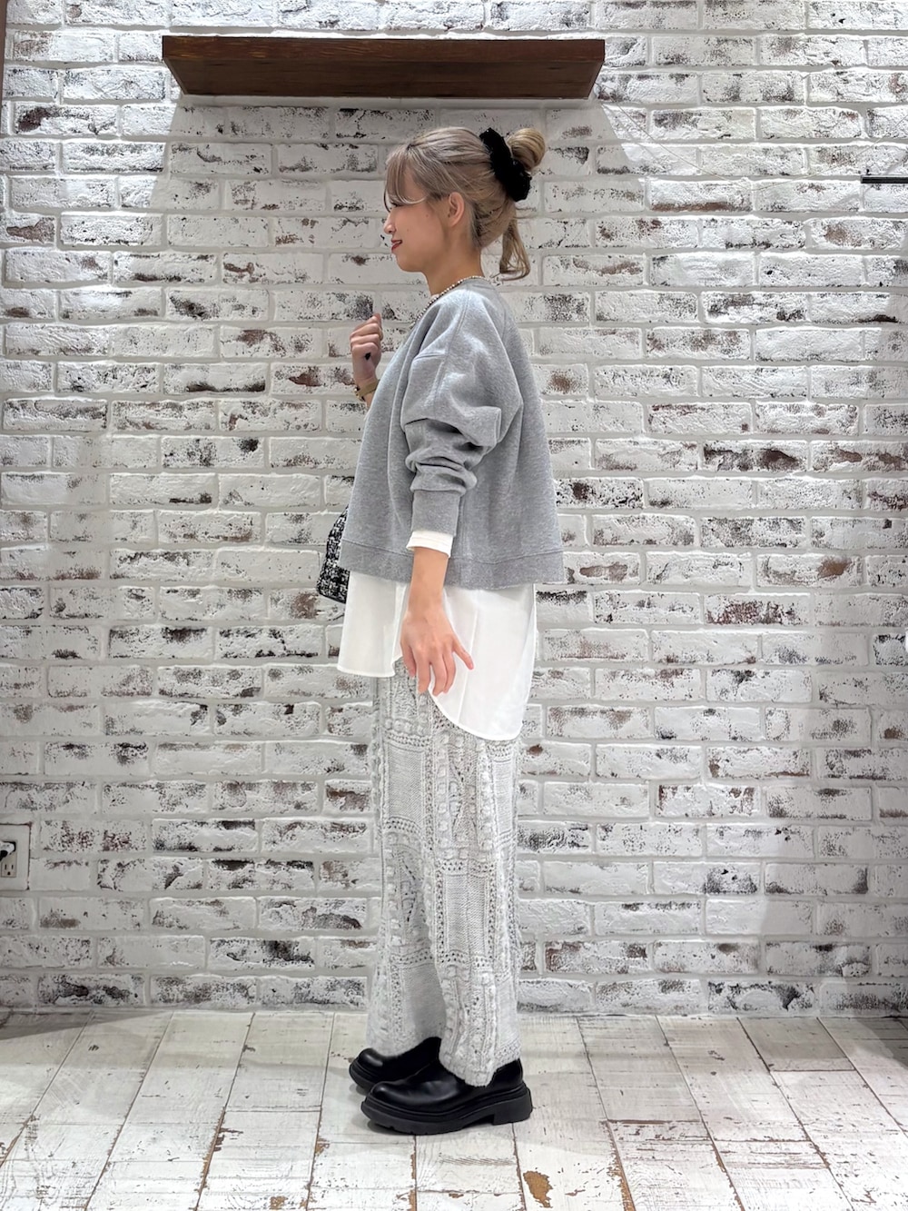 グレー系のスウェット、ホワイト系のシャツ/ブラウス、ベージュ系のスカートを着用したレディースの冬コーディネートの2枚目の写真