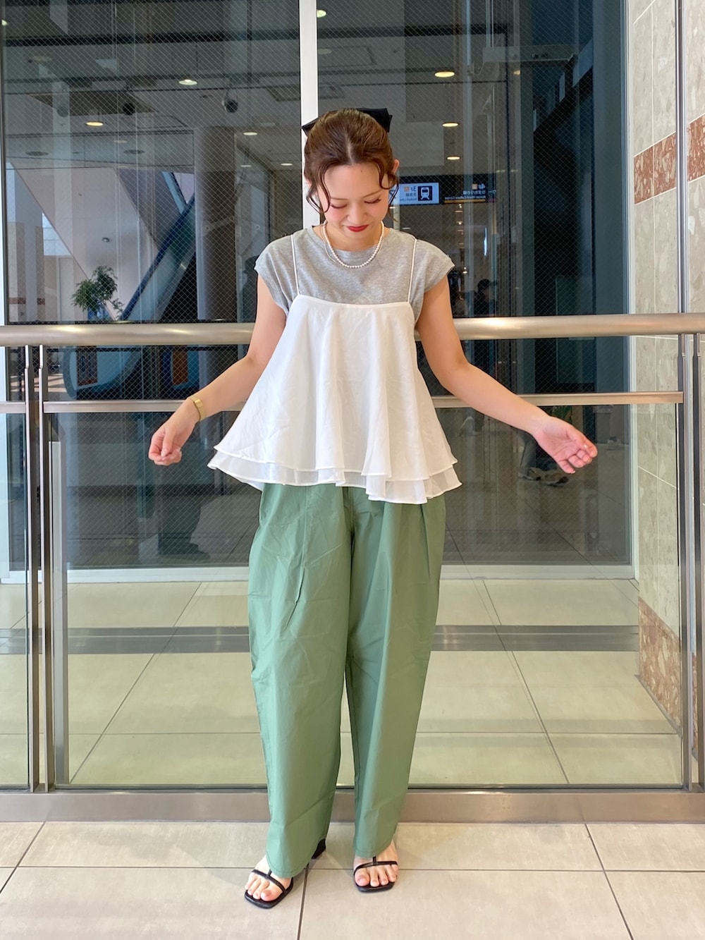 ホワイト系のキャミソール、グリーン系のパンツ、グレー系のTシャツ/カットソーを着用したレディースの春コーディネートの2枚目の写真