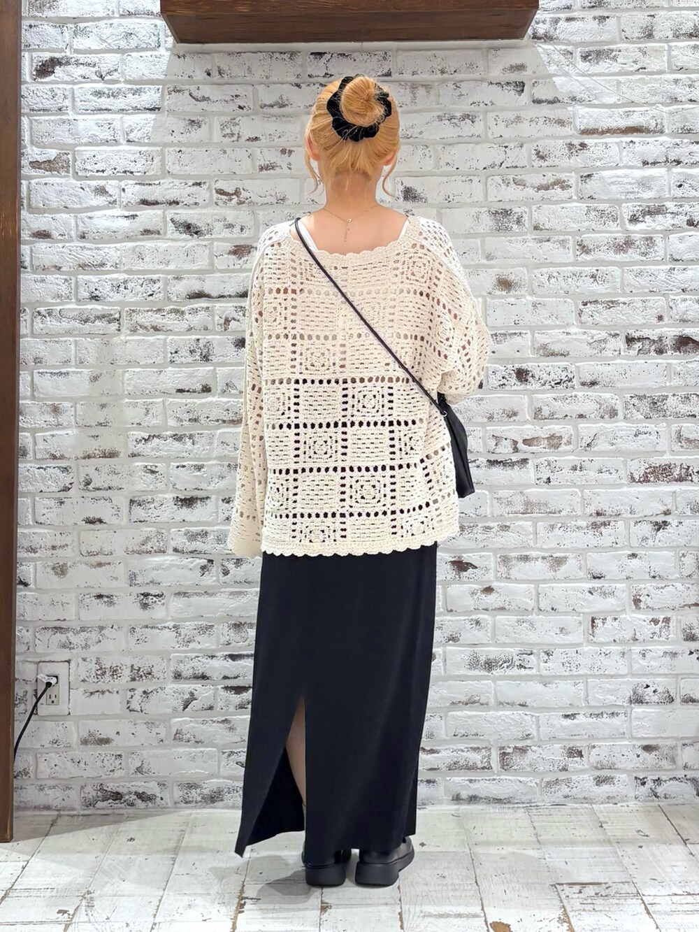 ホワイト系のニット/セーター、ブラック系のスカート、ブラック系のショルダーバッグを着用したレディースの秋コーディネートの3枚目の写真