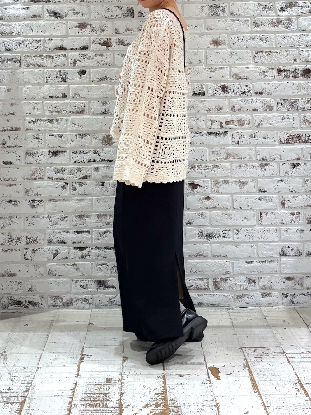 ホワイト系のニット/セーター、ブラック系のスカート、ブラック系のショルダーバッグを着用したレディースの秋コーディネートの2枚目の写真