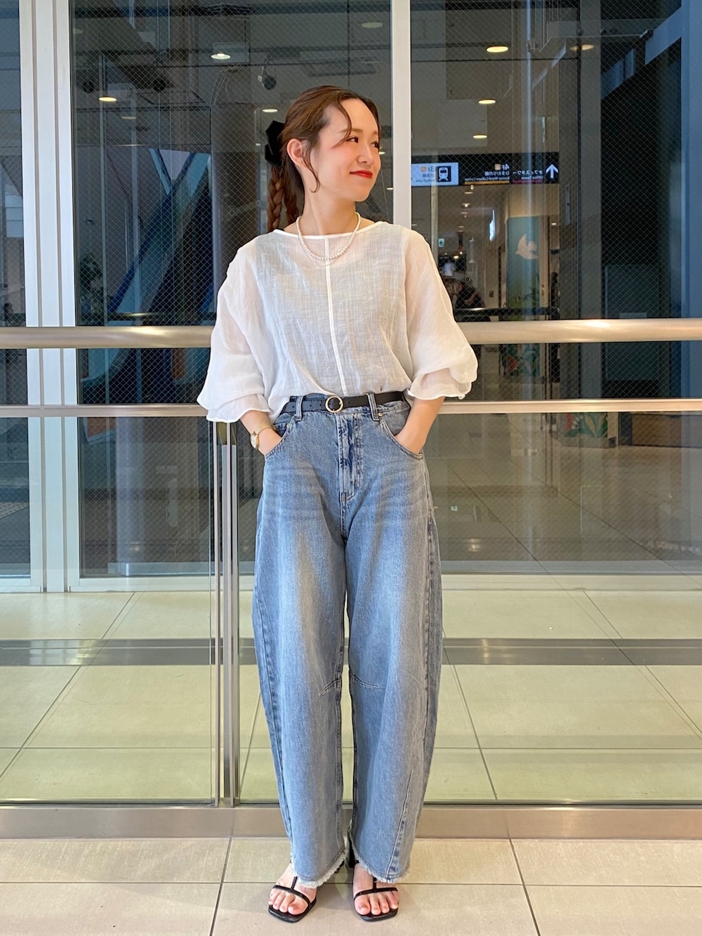 ブルー系のデニムパンツ、ホワイト系のシャツ/ブラウスを着用したレディースの夏コーディネートの2枚目の写真