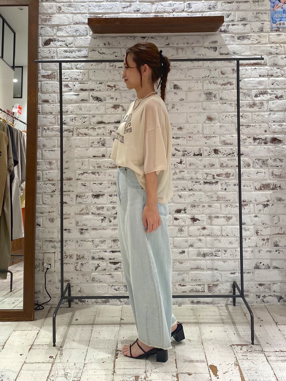 ブルー系のデニムパンツ、ホワイト系のタンクトップ、ホワイト系のニット/セーターを着用したレディースの夏コーディネートの2枚目の写真