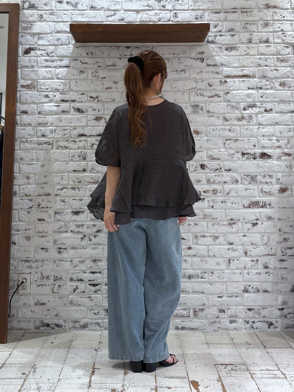 ブラック系のシャツ/ブラウス、ブルー系のデニムパンツ、ブラック系のサンダルを着用したレディースの夏コーディネートの3枚目の写真