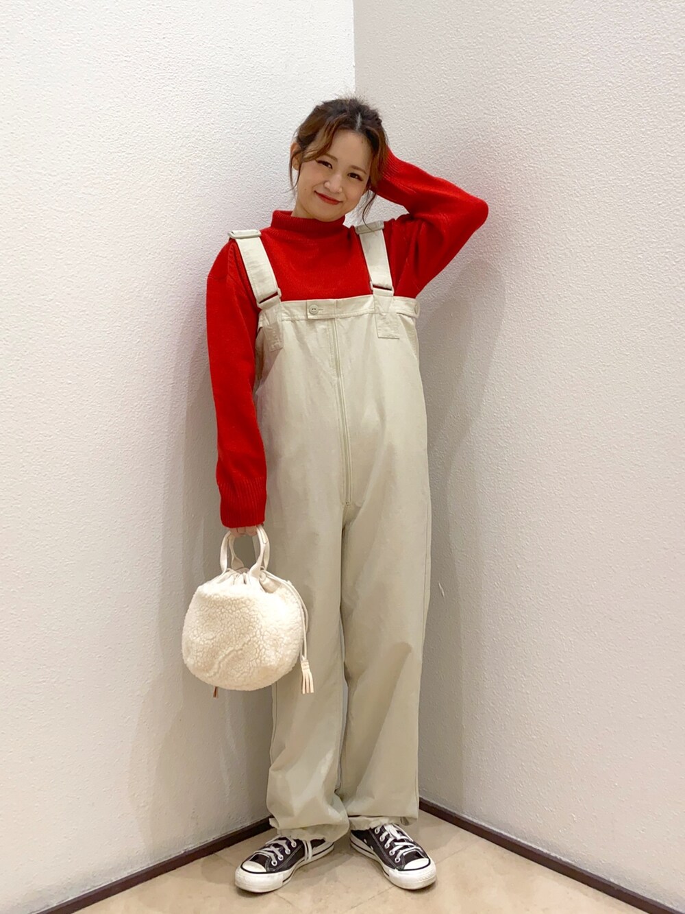 レッド系のニット/セーター、ブラウン系のスニーカーを着用したレディースの秋コーディネートの2枚目の写真