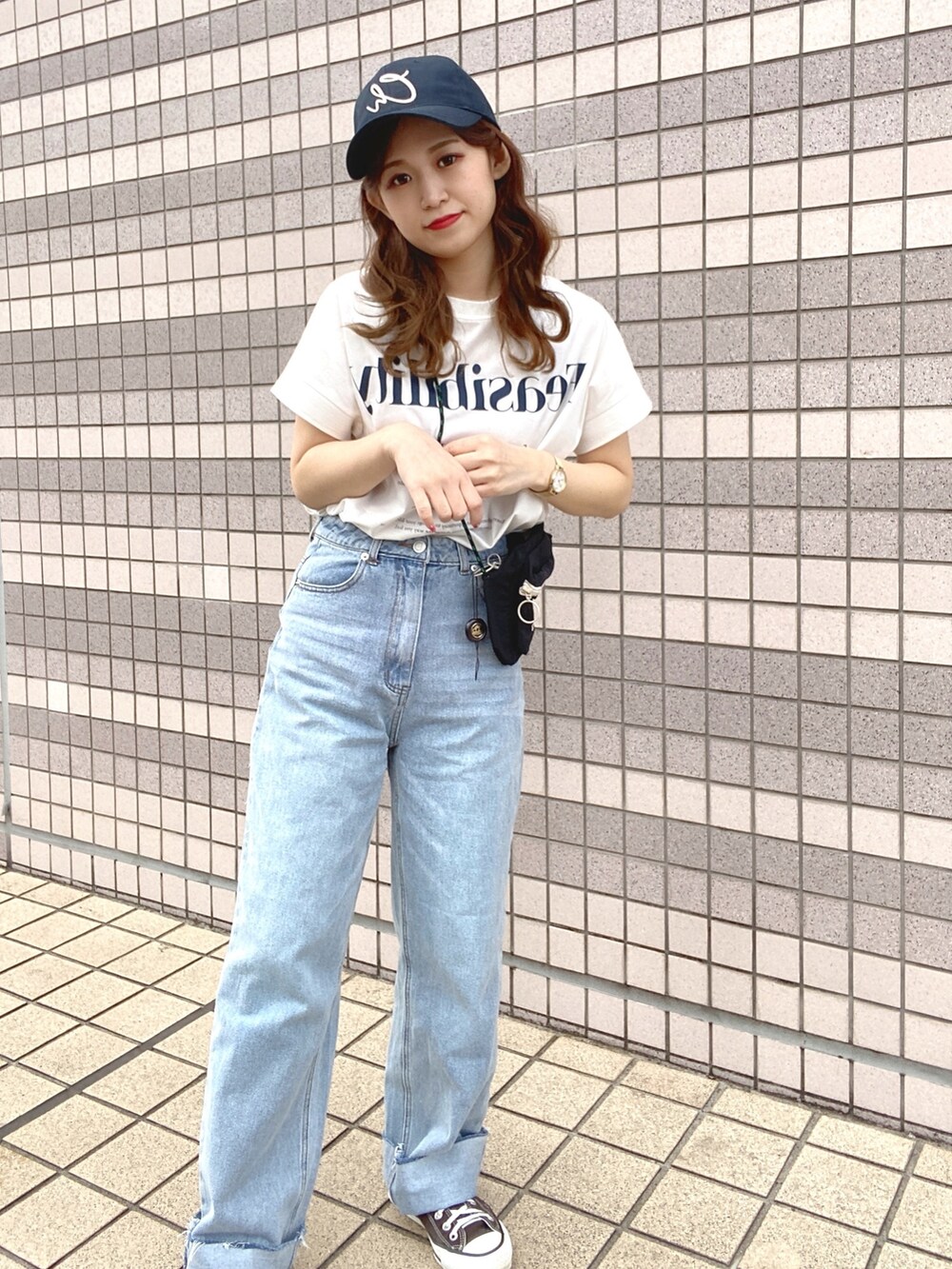 ブルー系のデニムパンツ、ブラウン系のスニーカー、ホワイト系のTシャツ/カットソーを着用したレディースの春コーディネートの2枚目の写真