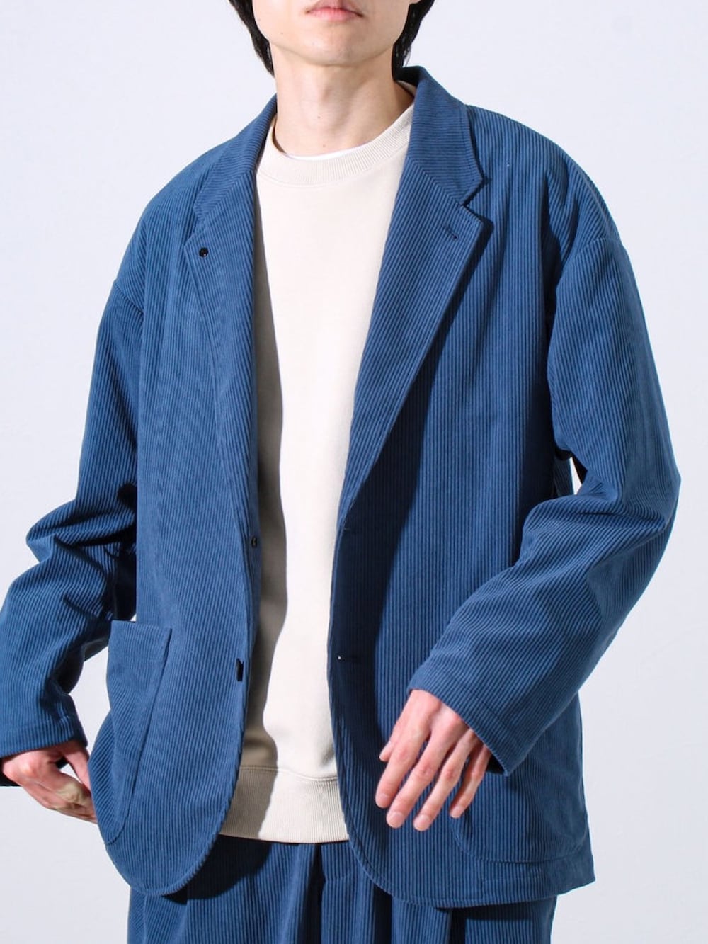 ブルー系のテーラードジャケット、ブルー系のその他パンツ、ベージュ系のスウェットを着用したメンズの冬コーディネートの2枚目の写真