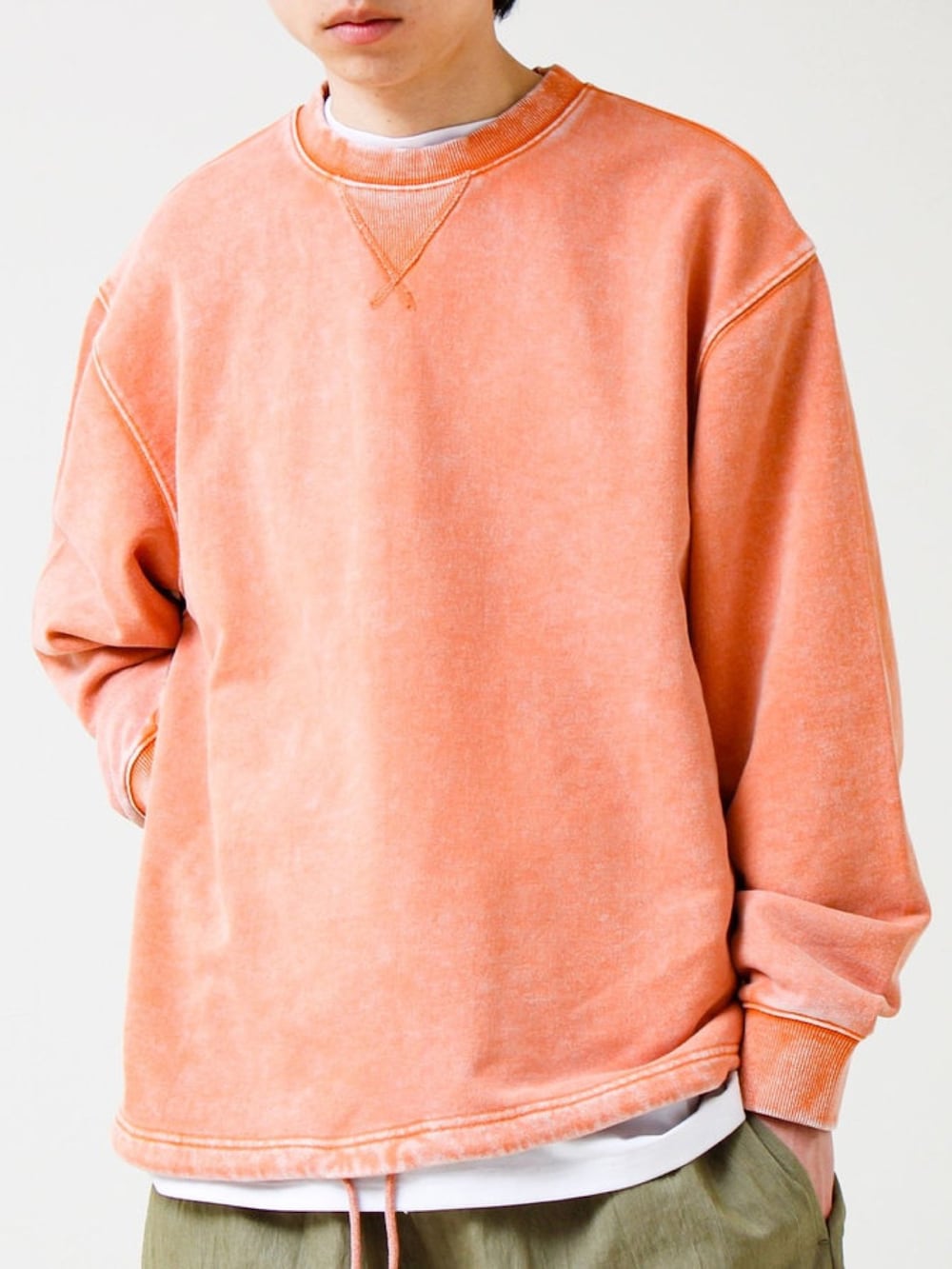 オレンジ系のスウェット、グリーン系のその他パンツを着用したメンズの冬コーディネートの2枚目の写真