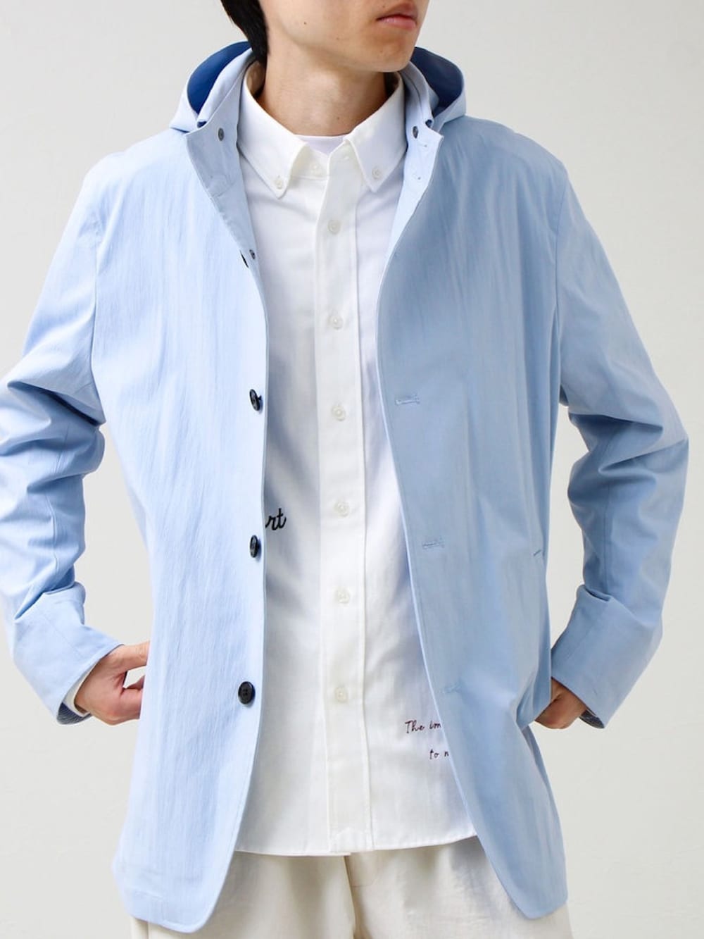 ブルー系のブルゾン、ホワイト系のその他パンツを着用したメンズの春コーディネートの2枚目の写真