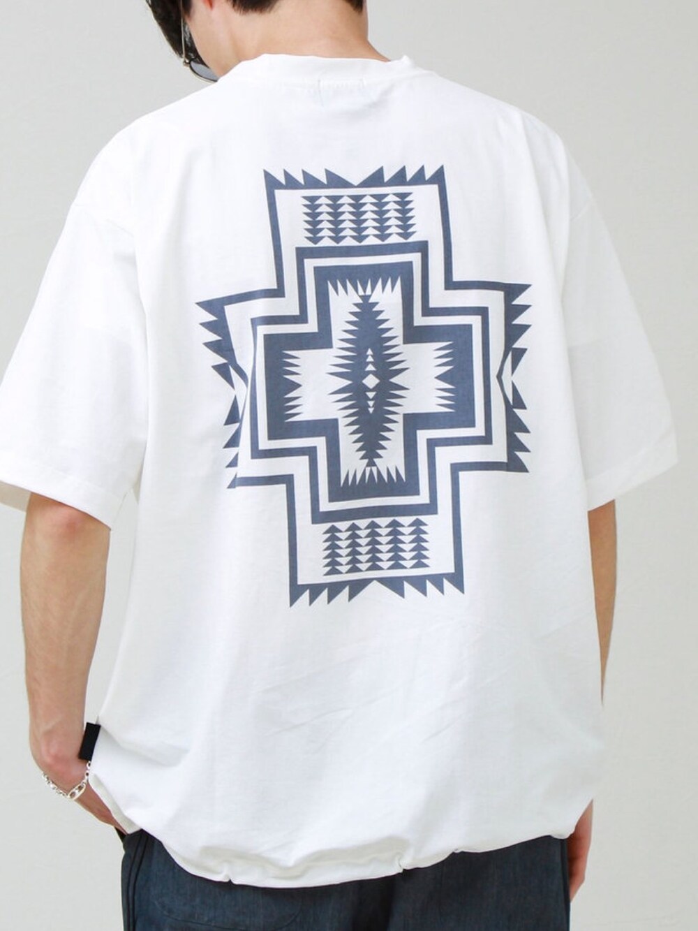 ホワイト系のTシャツ/カットソー、オレンジ系のショルダーバッグ、ブルー系のその他パンツを着用したメンズの春コーディネートの2枚目の写真