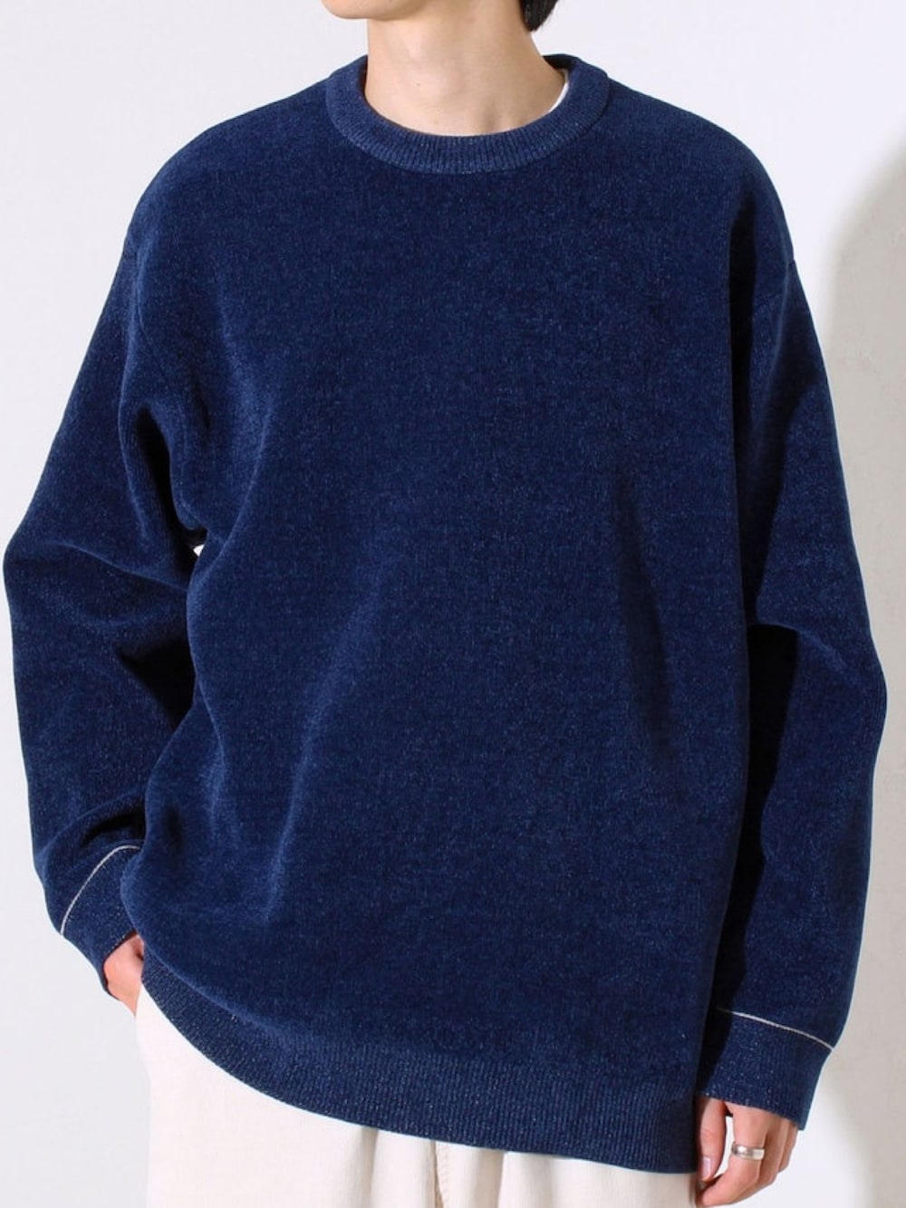 ブルー系のニット/セーター、ホワイト系のその他パンツを着用したメンズの秋コーディネートの2枚目の写真