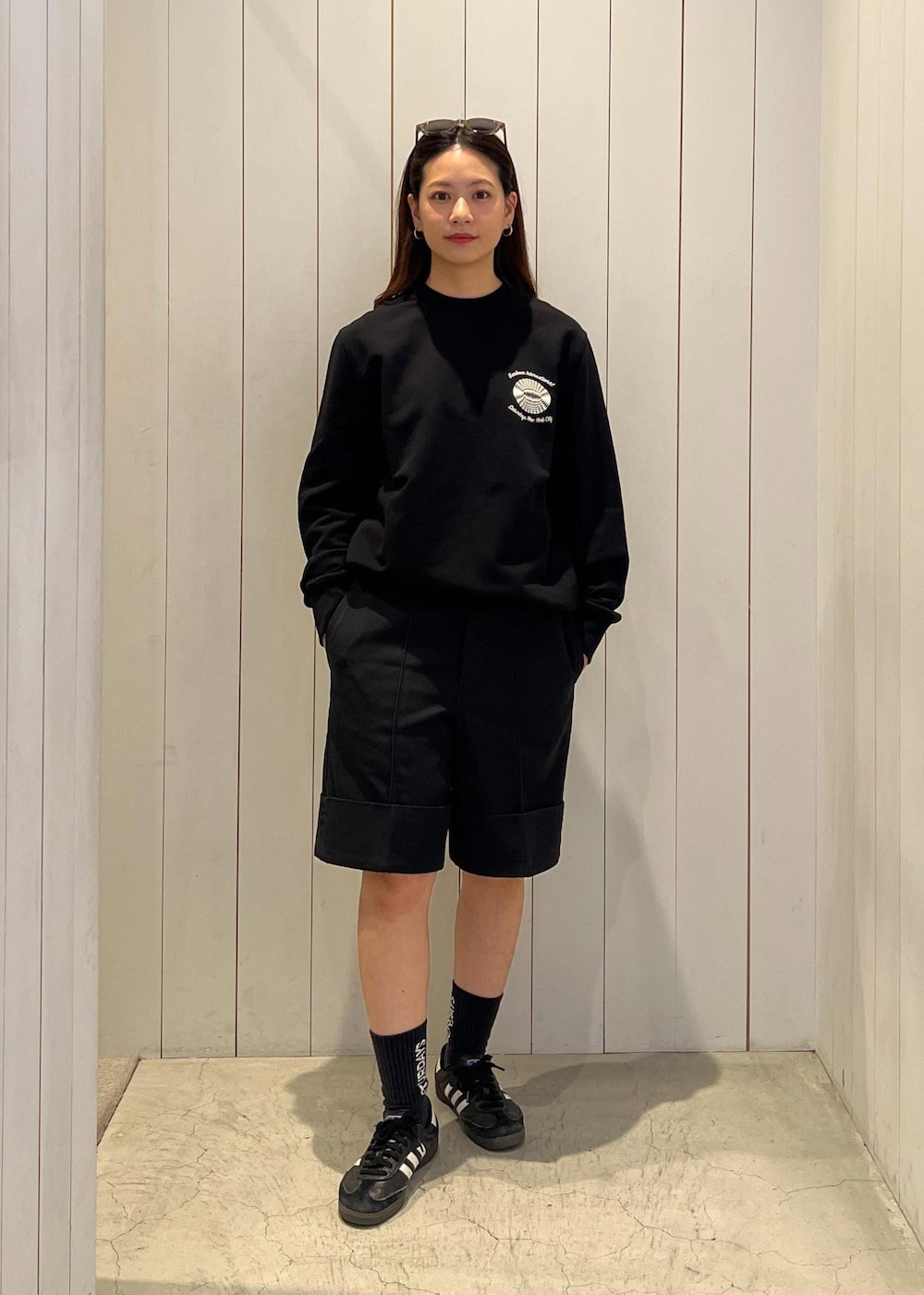 ブラック系のその他パンツ、ブラック系のソックス/靴下、ベージュ系のサングラスを着用したレディースの春コーディネートの2枚目の写真