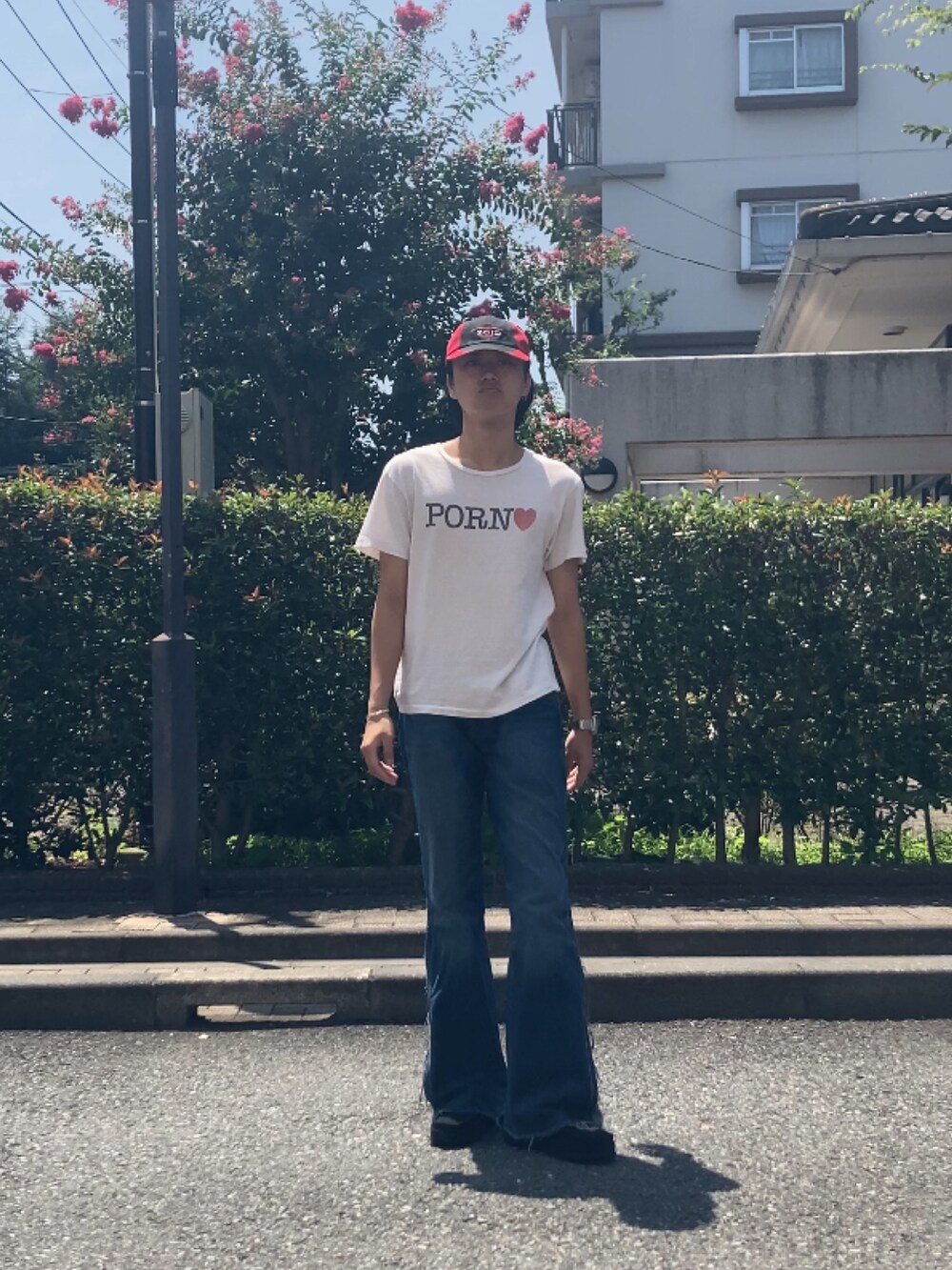 ホワイト系のTシャツ/カットソー、ブルー系のデニムパンツ、ブラック系のモカシン/デッキシューズを着用したメンズの夏コーディネートの2枚目の写真