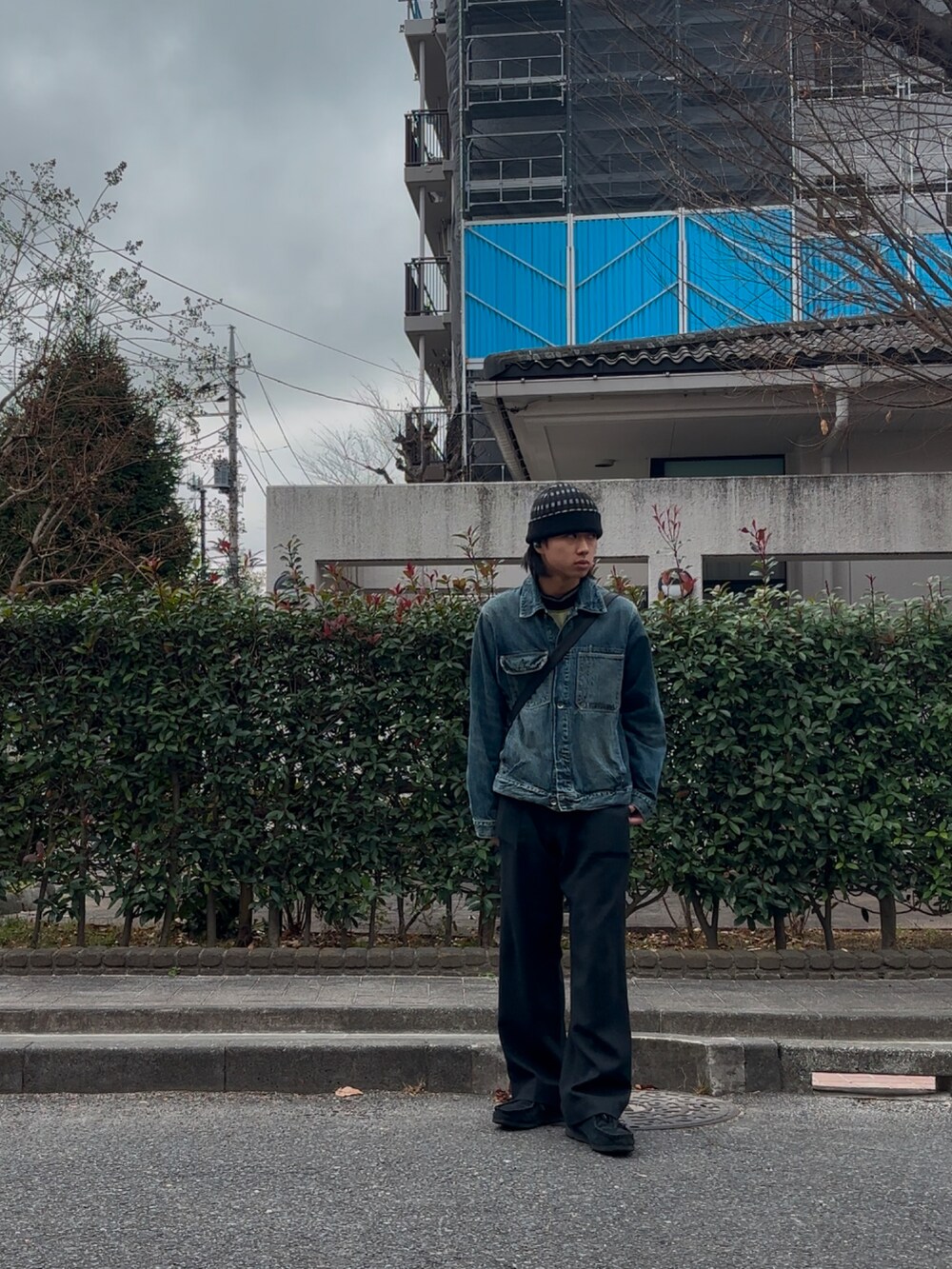 ブルー系のデニムジャケット、ブラック系のスラックスを着用したメンズの冬コーディネートの2枚目の写真