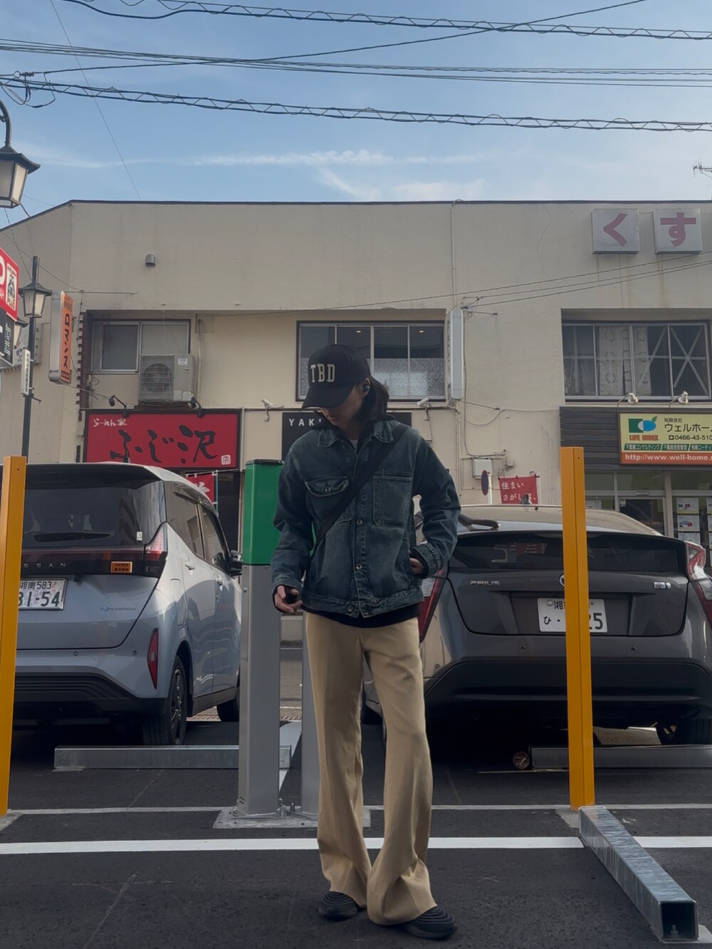 ベージュ系のスラックス、ブルー系のデニムジャケットを着用したメンズの春コーディネートの2枚目の写真