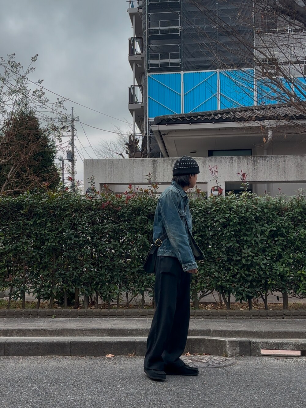 ブルー系のデニムジャケット、ブラック系のスラックスを着用したメンズの冬コーディネートの3枚目の写真