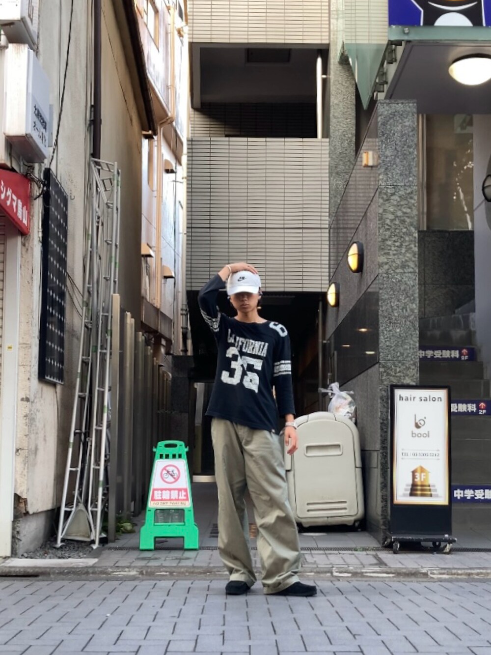 グリーン系のスラックス、ブラック系のTシャツ/カットソーを着用したメンズの夏コーディネートの3枚目の写真