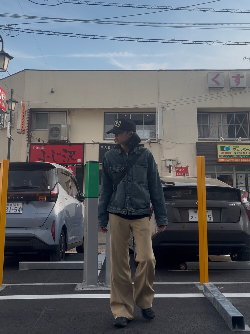 ベージュ系のスラックス、ブルー系のデニムジャケットを着用したメンズの春コーディネートの4枚目の写真