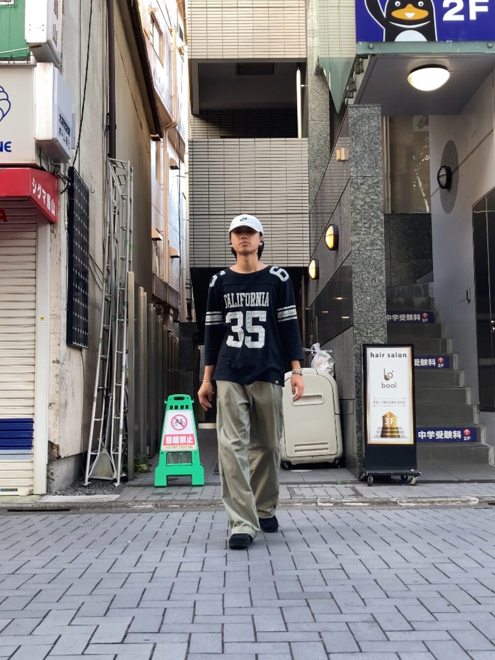 グリーン系のスラックス、ブラック系のTシャツ/カットソーを着用したメンズの夏コーディネートの4枚目の写真