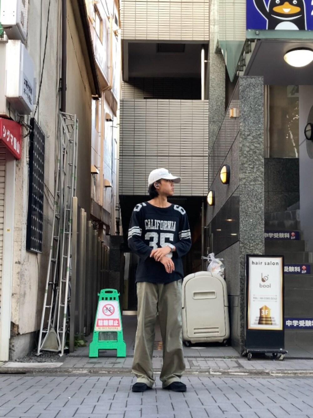 グリーン系のスラックス、ブラック系のTシャツ/カットソーを着用したメンズの夏コーディネートの2枚目の写真