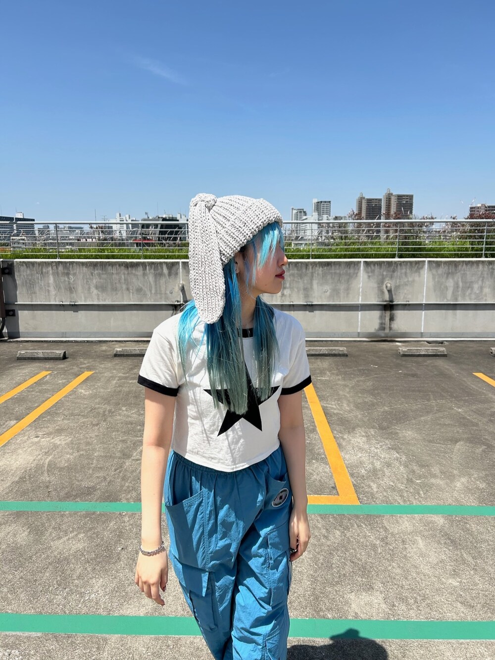 ホワイト系のTシャツ/カットソー、ブルー系のカーゴパンツ、ブラック系のスニーカーを着用したレディースの春コーディネートの3枚目の写真