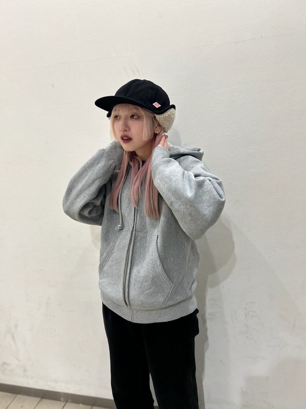 ブラック系のデニムパンツ、ブラウン系のスニーカー、ブラック系のキャップを着用したレディースの冬コーディネートの3枚目の写真