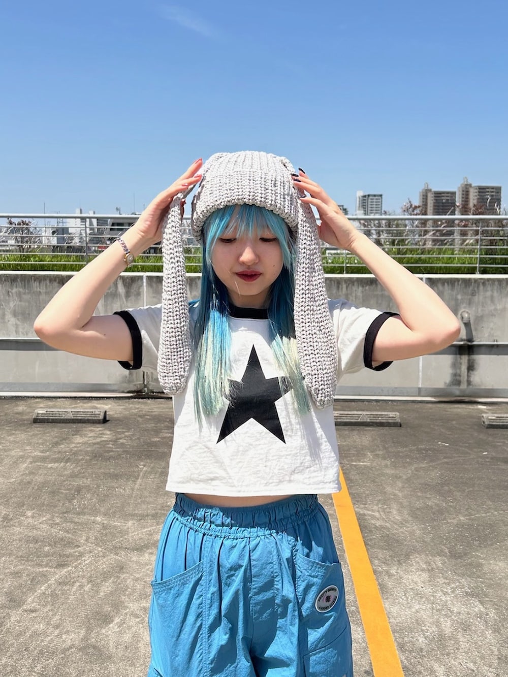 ホワイト系のTシャツ/カットソー、ブルー系のカーゴパンツ、ブラック系のスニーカーを着用したレディースの春コーディネートの2枚目の写真