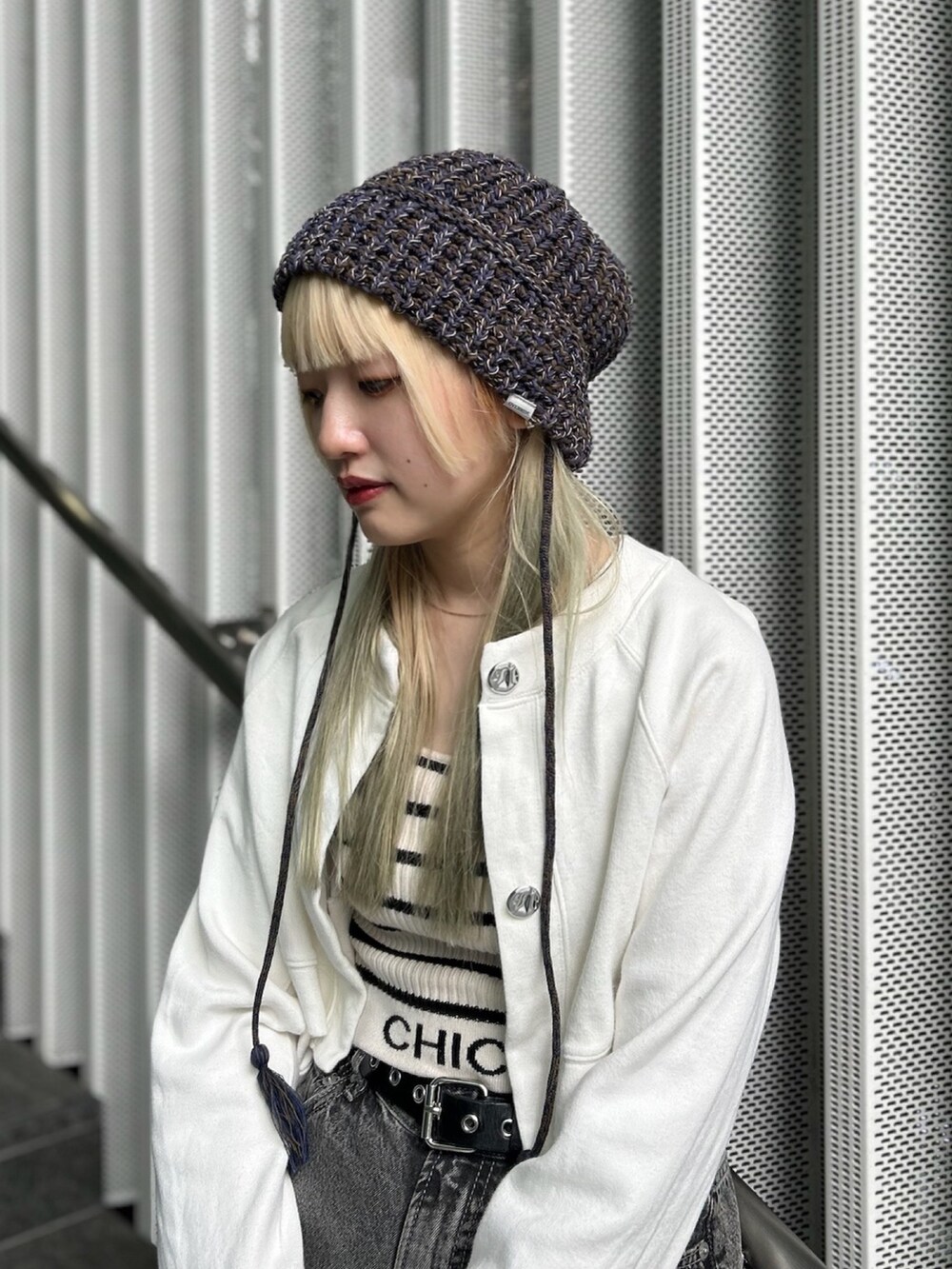 ブラック系のスニーカー、ブルー系のハットを着用したレディースの秋コーディネートの2枚目の写真