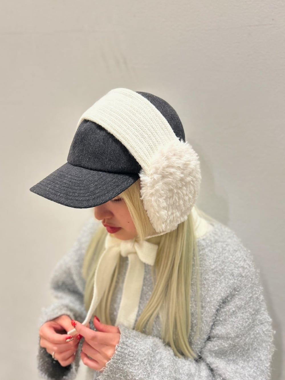 ホワイト系のイヤーマフ、グレー系のキャップを着用したレディースの冬コーディネートの2枚目の写真