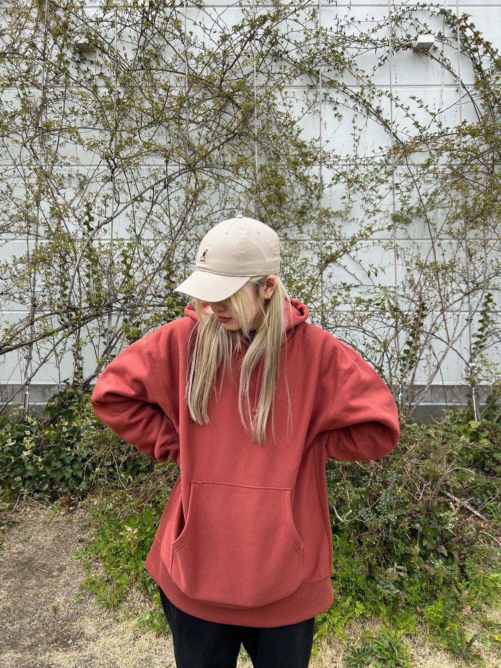 ブラック系のデニムパンツ、ブラウン系のスニーカー、ベージュ系のキャップを着用したレディースの春コーディネートの2枚目の写真