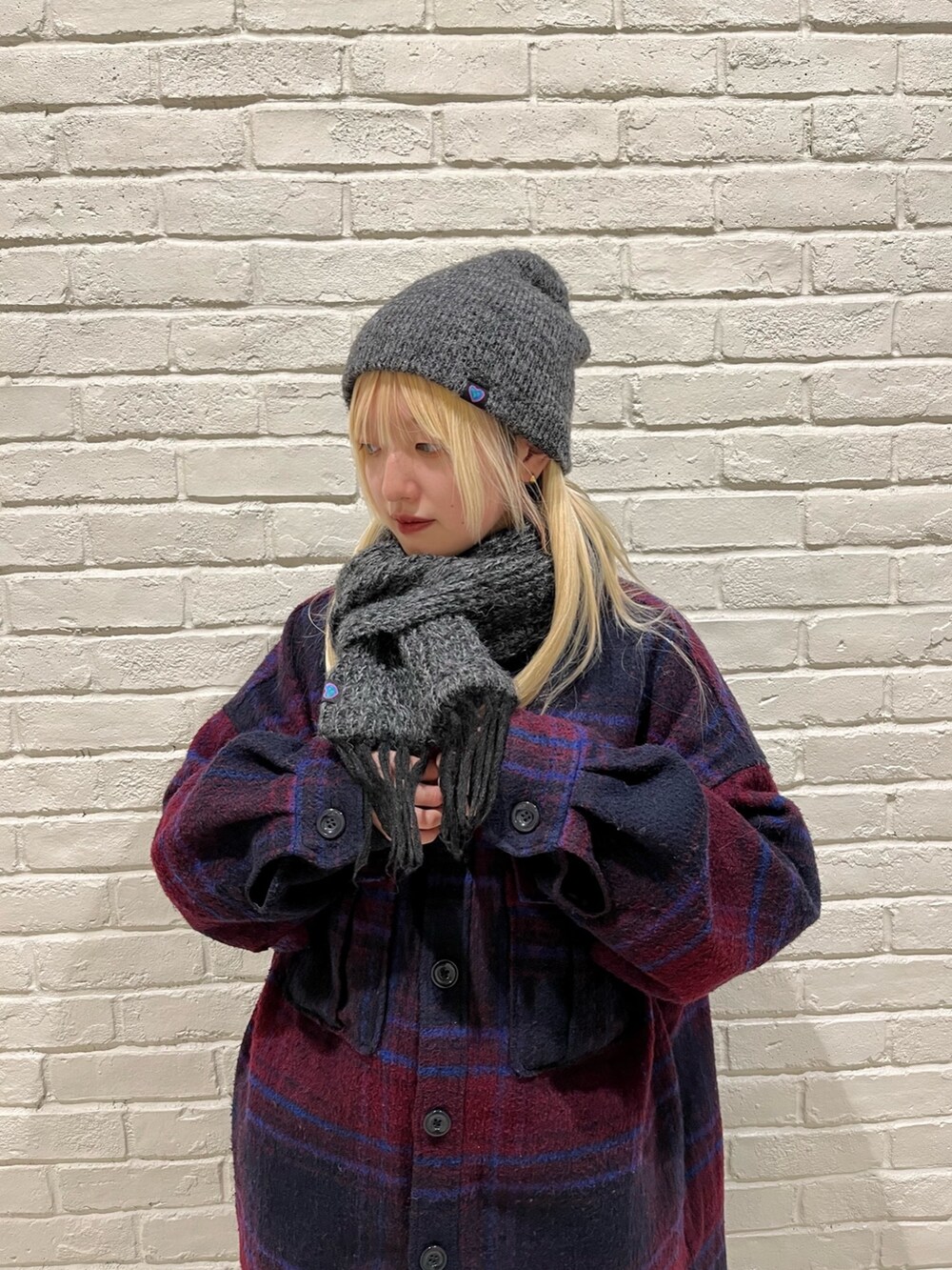 レッド系のジャケット/アウター、ホワイト系のスニーカー、グレー系のニットキャップ/ビーニーを着用したレディースの冬コーディネートの2枚目の写真