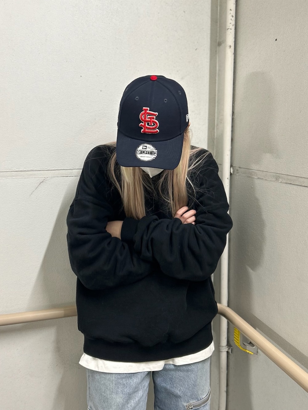 ブラウン系のスニーカー、ブルー系のキャップを着用したレディースの冬コーディネートの2枚目の写真