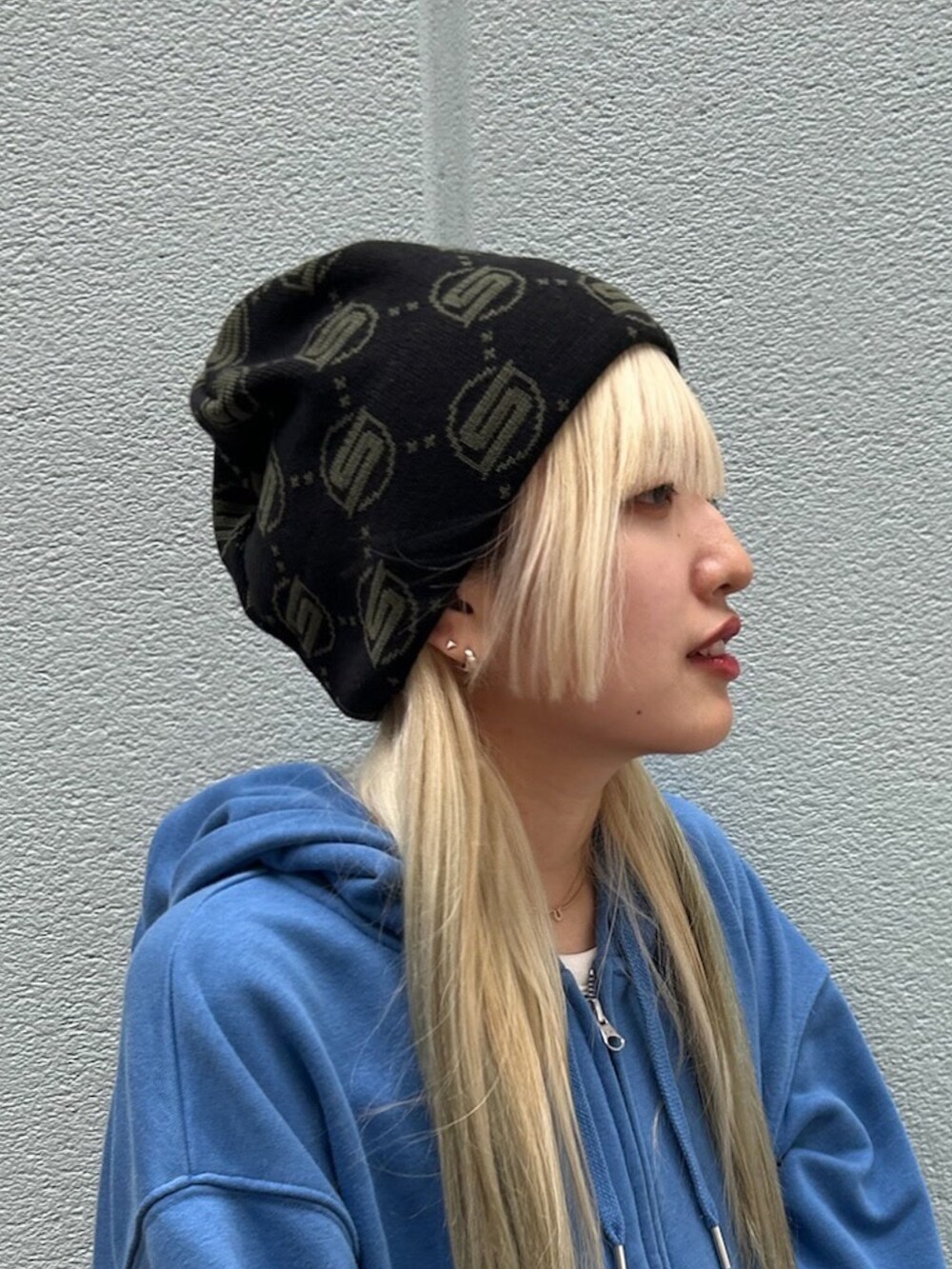 ブラック系のデニムパンツ、ブラウン系のスニーカー、ブラック系のニットキャップ/ビーニーを着用したレディースの秋コーディネートの2枚目の写真