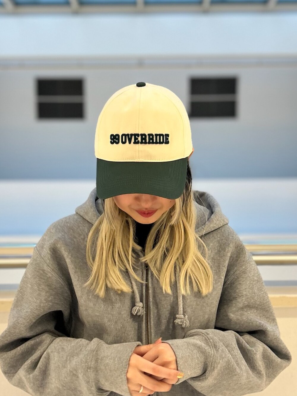 グリーン系のキャップを着用したレディースの冬コーディネートの2枚目の写真