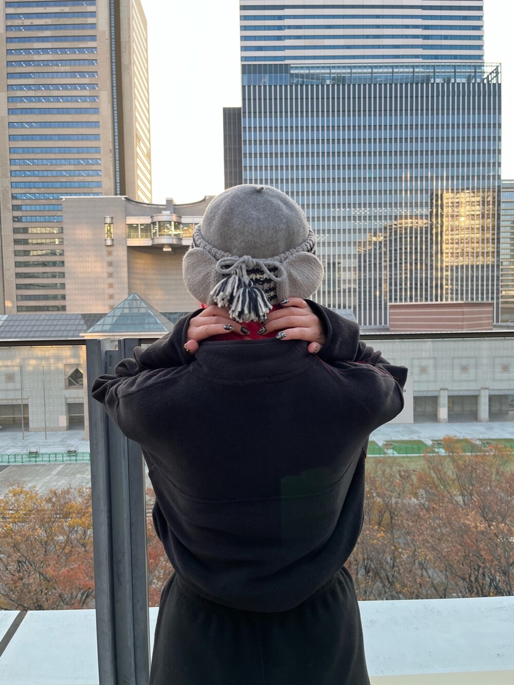 ブラック系のトップス、ブラック系のパンツ、ホワイト系のスニーカーを着用したレディースの冬コーディネートの2枚目の写真