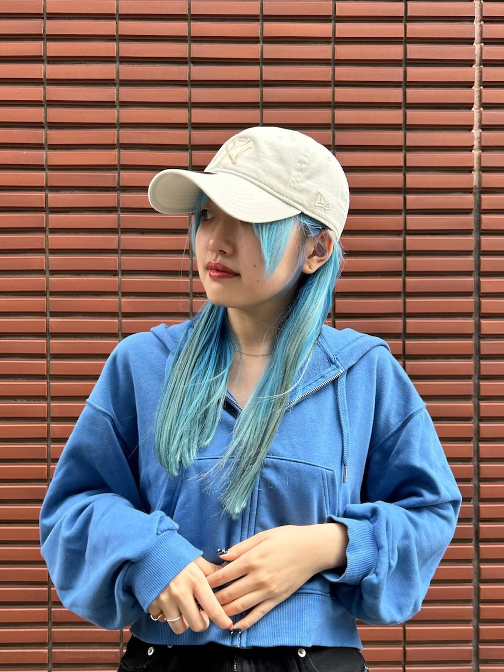 ブラック系のスニーカー、ブラック系のデニムパンツ、ベージュ系のキャップを着用したレディースの春コーディネートの3枚目の写真