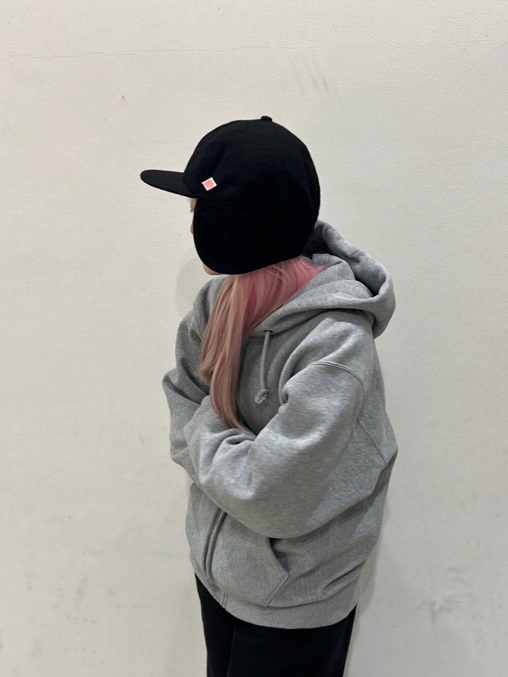 ブラック系のデニムパンツ、ブラウン系のスニーカー、ブラック系のキャップを着用したレディースの冬コーディネートの4枚目の写真