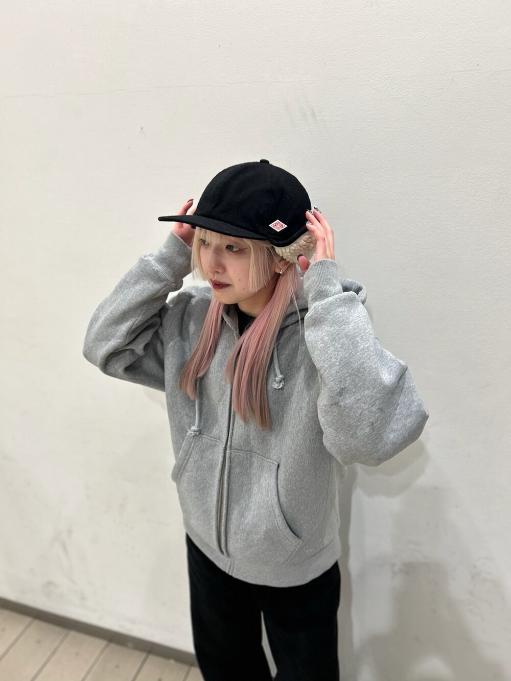 ブラック系のデニムパンツ、ブラウン系のスニーカー、ブラック系のキャップを着用したレディースの冬コーディネートの2枚目の写真