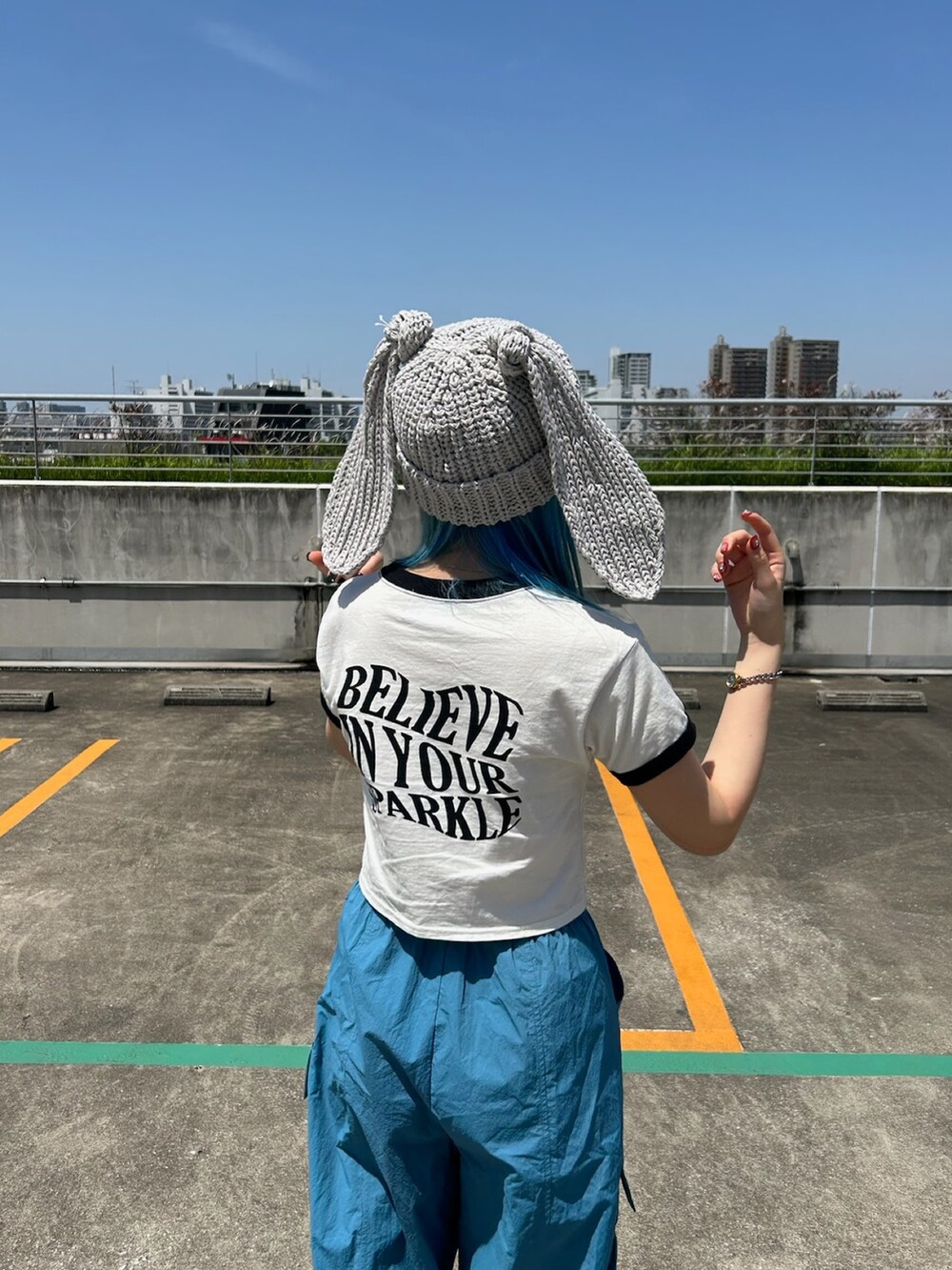 ホワイト系のTシャツ/カットソー、ブルー系のカーゴパンツ、ブラック系のスニーカーを着用したレディースの春コーディネートの5枚目の写真